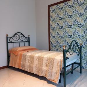 a bedroom with a bed and a chair and a wall at New Magnolia House in Belpasso