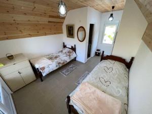 ein Schlafzimmer mit zwei Betten in einem Zimmer mit Holzdecke in der Unterkunft Vikendice Ivanović in Prisoja