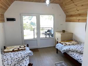 ein Zimmer mit zwei Betten und einem Balkon mit einem Tisch in der Unterkunft Vikendice Ivanović in Prisoja