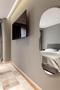 a bedroom with a bed and a tv on the wall at Agate Hotel Tirana in Tirana +118 photos