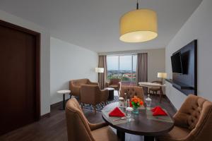 a living room with a table and chairs at Amandaru Hotel Pekalongan in Pekalongan