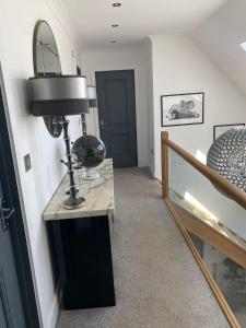 ein Flur mit einem Tisch mit einer Lampe und einer Treppe in der Unterkunft Hillvine in Hartpury