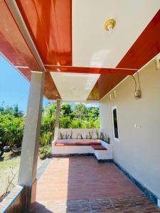 a porch of a house with a bench at Tiba Meka Homestay in Komodo Labuan Bajo Airport