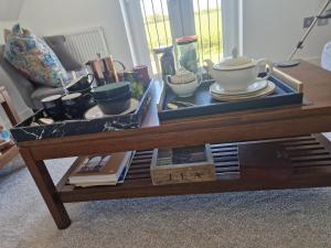 ein Couchtisch mit einem Tablett mit Geschirr darauf in der Unterkunft Hillvine in Hartpury