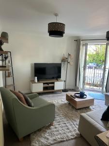 a living room with a green couch and a television at Beautiful 2 bed in Wycombe in High Wycombe