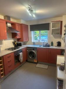 a kitchen with red cabinets and a washing machine at Beautiful 2 bed in Wycombe in High Wycombe