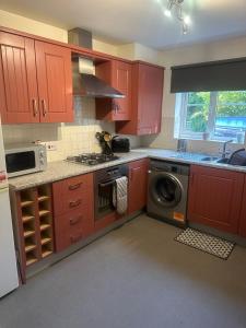 a kitchen with red cabinets and a washing machine at Beautiful 2 bed in Wycombe in High Wycombe +6 photos