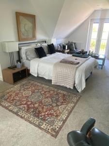 ein Schlafzimmer mit einem großen Bett und einem Teppich in der Unterkunft Hillvine in Hartpury