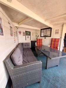 a room with a table and a couch and a table and a couch sidx sidx at Happy Place is een modern en comfortabel chalet met een grote afgesloten tuin op de Veluwe, Recreatiepark De oude Driest in Putten