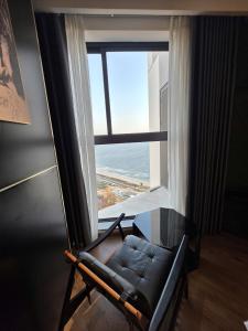 a couch in a room with a large window at Mandala Chambay Mũi Né - TAQ in Mui Ne