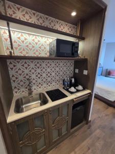 a small kitchen with a sink and a microwave at Mandala Chambay Mũi Né - TAQ in Mui Ne