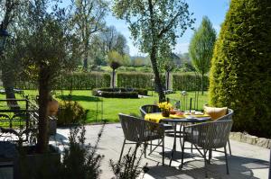 a patio with a table and chairs in a garden at Landhaus Riedl in Bad Füssing
