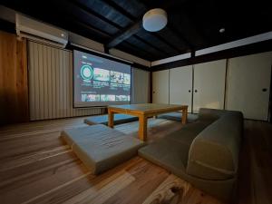 a room with a couch and a table and a screen at 古民家宿 Mutsu Traditional Japanese House Inn MUTSU in Ōtaki