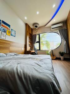 a bedroom with a large bed and a large window at Ruby Home Quy Nhon in Quy Nhon +8 photos