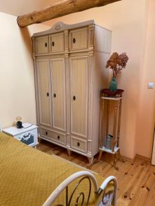 a bedroom with a bed and a large wooden cabinet at Marokanski domek in Mielnik