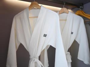 a group of white shirts hanging on a rack at OOD Hotel Taipei DunhuaNorth in Taipei