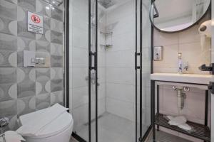 a bathroom with a shower and a toilet and a sink at Miralya Rooms in Fethiye