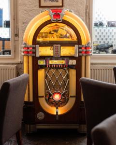 a jukebox sitting in a room with two chairs at B&B Fotić in Zagreb