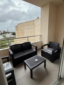 a balcony with a couch and two chairs and a table at Sublime appartement F4 a draria in Alger