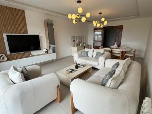 a living room with couches and a flat screen tv at Sublime appartement F4 a draria in Alger
