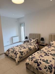 a bedroom with two beds and a window at Sublime appartement F4 a draria in Alger