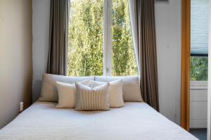 a bed with white pillows in front of a window at Bed zonder Breakfast in Amsterdam