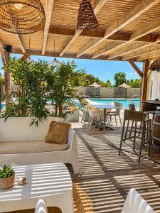 a patio with a couch and tables and a pool at Cala Serena Saint Cyprien in Lecci
