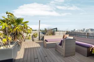 a rooftop deck with a couch and plants at Bed zonder Breakfast in Amsterdam