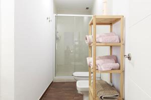 a bathroom with a toilet and a shower with pink towels at Duplex con vistas en el centro de Aracena in Aracena