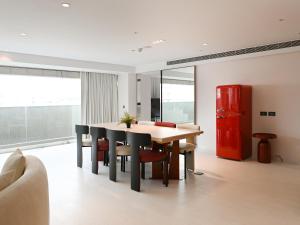 a dining room with a table and chairs and a red refrigerator at OOD Hotel Taipei DunhuaNorth in Taipei