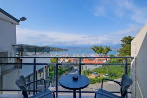 a balcony with a table and chairs and a view of the water at Miralya Rooms in Fethiye