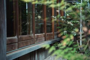 a wooden window on a building with a bush at 宿屋 余白丨yadoya yohaku in Wakayama