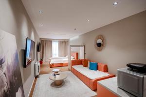 a hotel room with a couch and a bed at Agate Hotel Tirana in Tirana
