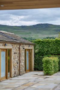 a stone house with glass doors and a stone wall at The Angel at Hetton in Hetton