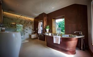 a large bathroom with a copper tub and a sink at The Angel at Hetton in Hetton