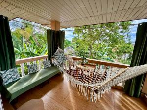 a porch with a hammock on a balcony at Bananaland Cottages in Panglao Island