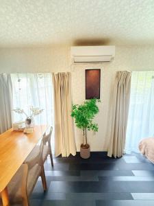 a dining room with a table and a potted plant at aiki home in Tokyo