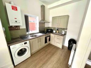 a kitchen with a washer and a sink and a washing machine at The Limes! Flat 3 Private Studio Apartment in Quinton