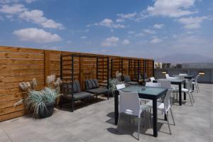 a patio with tables and chairs on a roof at Razin 37 in Eilat