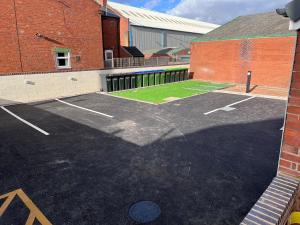 a parking lot in front of a brick building at The Limes! Flat 3 Private Studio Apartment in Quinton +3 photos
