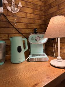 a table with a coffee maker and a lamp on it at Apartament Maki Apartament na wyłączność in Krynica Morska