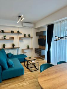 a living room with a blue couch and a table at Emerald Luxury Apartments in Skopje