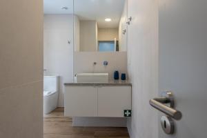 a bathroom with a sink and a toilet at Cozy Oeiras Home for Beach, Lisbon & Cascais in Paço de Arcos +14 photos