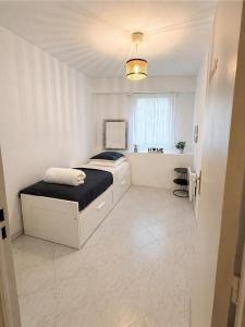 a white bedroom with a bed and a window at Le Saint Michel - MENTON#MONACO - 6 PERSONS - Parking- bord de mer in Menton