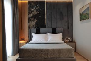 a bedroom with a large bed with white pillows at Vila-L Hotel in Tirana +67 photos