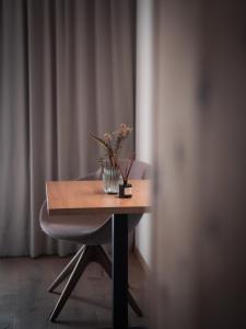 a wooden table with a vase of flowers on it at Das Panorama Dependance in Caldaro +37 photos