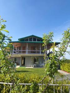 a large brick house with a balcony on a lawn at Highfield Villa in Kanatal