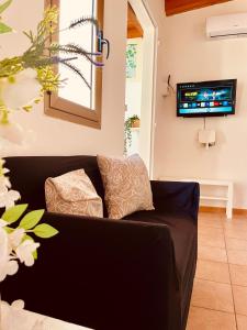 a black couch in a living room with a tv at DomuMnG in Elmas