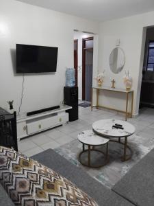 a living room with a flat screen tv on a wall at Achievers stays in Kitengela 