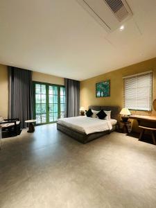 a large bedroom with a bed and a desk at PhuQuoc Homestay in Long Bình